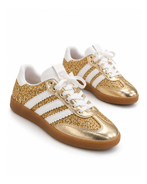 Detalle de los tenis Aure Gold con textura dorada luminosa, contrastes blancos y acabados sofisticados