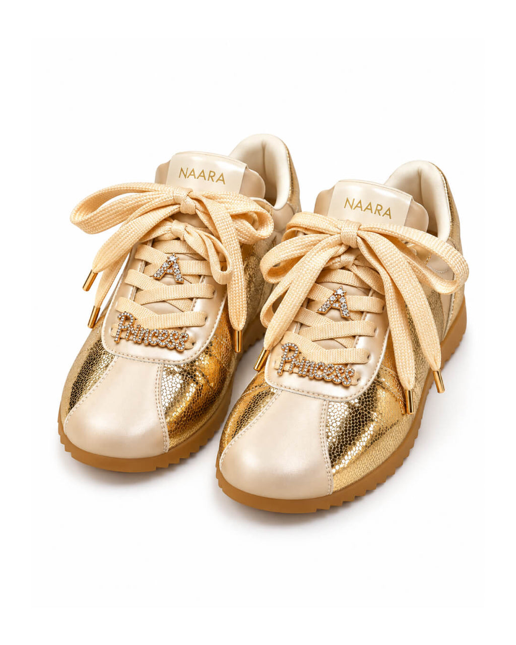 Tenis Aurelia con acabado dorado brillante, contrastes blancos y silueta moderna de inspiración urbana